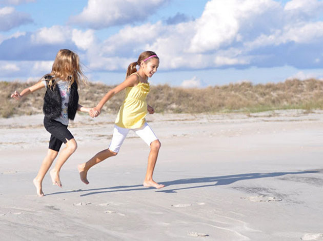Two friends running on the beach.